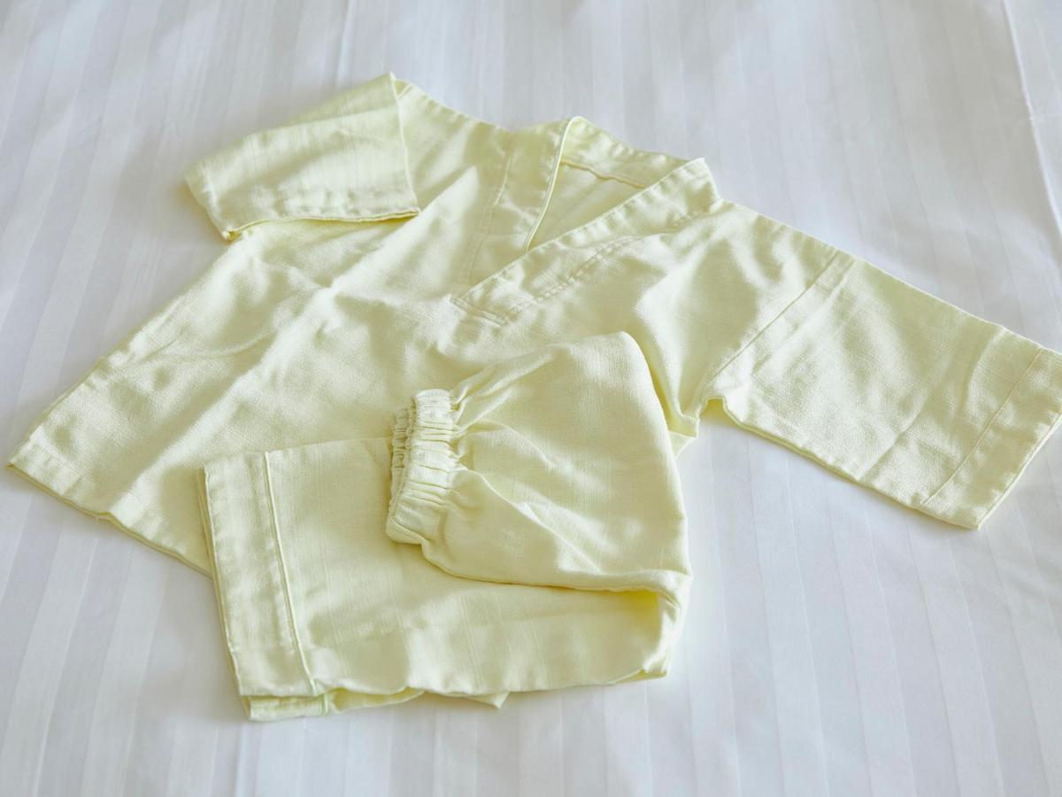 Grand Nikko Tokyo Bay Maihama Hotell Urayasu Exteriör bild The photo shows a small, traditional outfit made of light yellow fabric. The outfit includes a short-sleeved top with a V-neck and a pair of matching pants. The design is simple, featuring a loose fit and a comfortable style, making it suitable for c