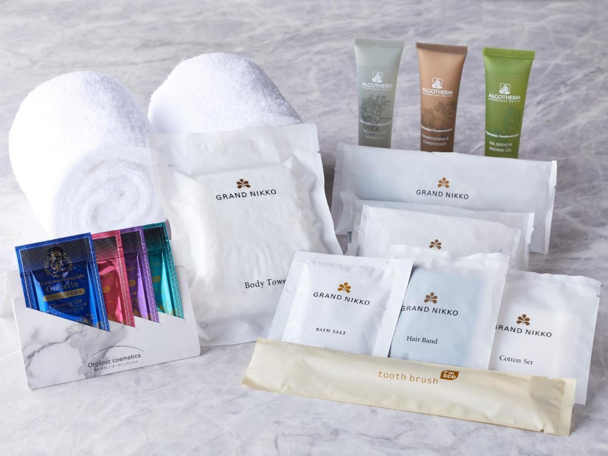Grand Nikko Tokyo Bay Maihama Hotell Urayasu Exteriör bild The photo displays a collection of spa or hotel toiletries. It includes:

- Two fluffy white towels.
- Multiple packages labeled "GRAND NAKO," which appear to be spa or body care products.
- Several small tubes of hair and body care items in green an